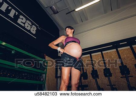 Stock Image - Pregnant woman standing in gym. Fotosearch