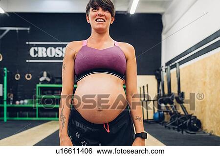 Stock Photograph - Pregnant woman standing in gym. Fotosearch