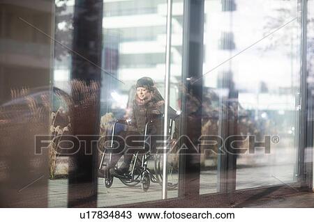 Reflection of woman in wheelchair on glass windows of building View Large Photo Image Stock Image - Reflection of woman in wheelchair on glass windows of building. Fotosearch