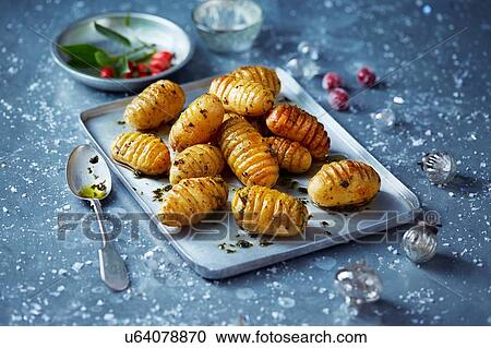Stock Image - Roast potatoes on baking tray, Christmas food. Fotosearch