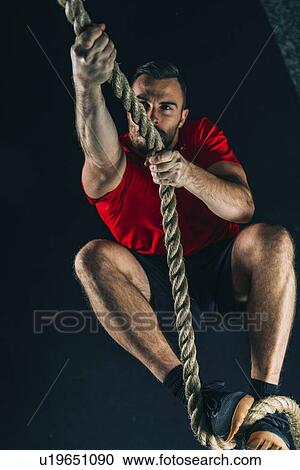 Stock Image - Rope climbing exercise. Fotosearch