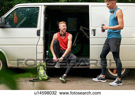Stock Image - Runner friends talking beside van. Fotosearch