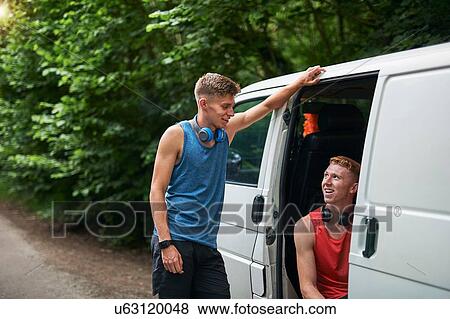 Stock Photo - Runner friends talking beside van. Fotosearch