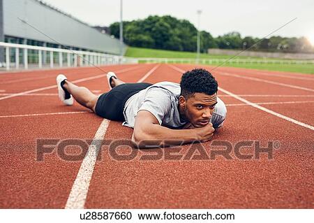 Runner lying on running track View Large Photo Image Stock Image - Runner lying on running track. Fotosearch