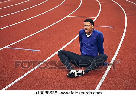 Stock Photography - Runner resting on running track. Fotosearch