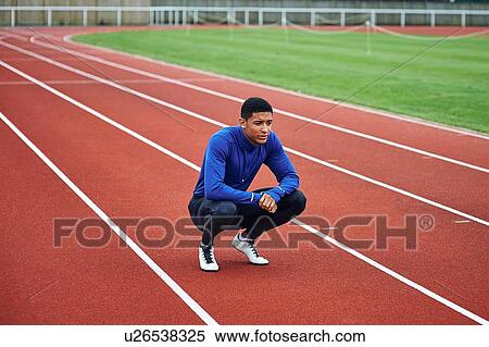 Stock Photography - Runner resting on running track. Fotosearch