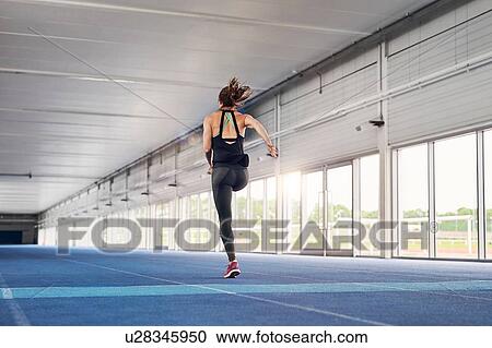 Stock Image - Runner training on indoor running track. Fotosearch