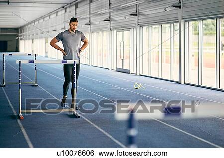 Stock Photograph - Runner training on indoor running track. Fotosearch