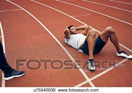 Runners resting on running track View Large Photo Image Stock Photo - Runners resting on running track. Fotosearch