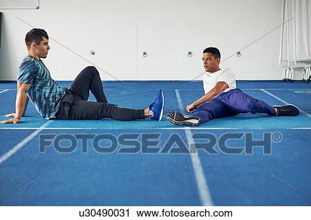 Runners sitting on indoor running track View Large Photo Image Stock Image - Runners sitting on indoor running track. Fotosearch