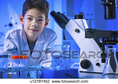 Stock Image - Schoolboy doing science experiment. Fotosearch