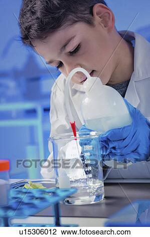 Stock Image - Schoolboy using lab equipment. Fotosearch