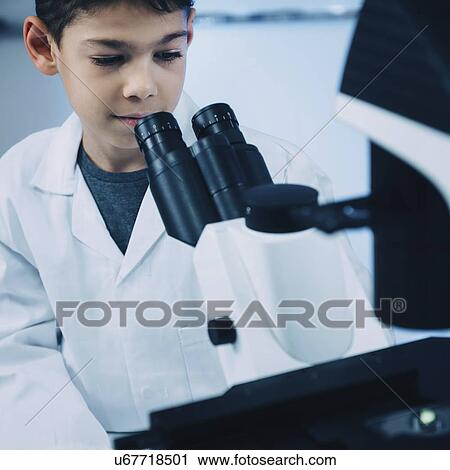 Stock Image - Schoolboy using light microscope. Fotosearch