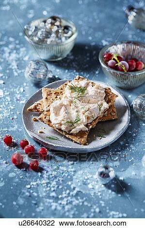 Stock Image - Seeded cracker with pate and dill on plate, seasonal Christmas food. Fotosearch