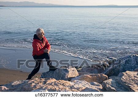 Senior man doing stretching exercises on beach, Livorno, Italy View Large Photo Image Stock Photo - Senior man doing stretching exercises on beach, Livorno, Italy. Fotosearch