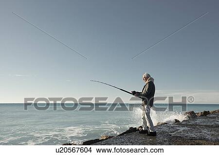 Picture - Senior man fishing, Livorno, Italy. Fotosearch