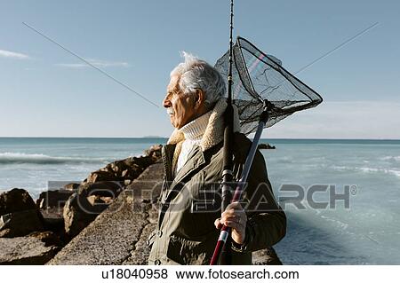 Stock Photo - Senior man going fishing, Livorno, Italy. Fotosearch