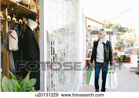 Stock Photo - Senior man outside clothes shop, Livorno, Italy. Fotosearch