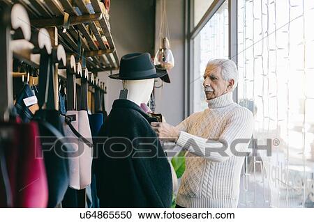 Senior man working in clothes shop View Large Photo Image Stock Image - Senior man working in clothes shop. Fotosearch