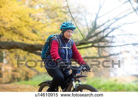 Senior woman cycling in park View Large Photo Image Stock Photography - Senior woman cycling in park. Fotosearch