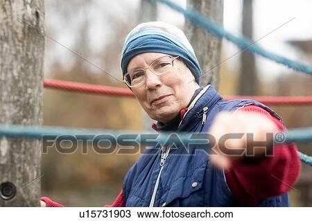 Stock Image - Senior woman exercising in park. Fotosearch