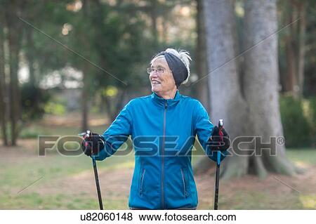 Senior woman nordic walking in park View Large Photo Image Stock Photo - Senior woman nordic walking in park. Fotosearch