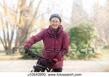 Senior woman on bicycle in park View Large Photo Image Stock Image - Senior woman on bicycle in park. Fotosearch