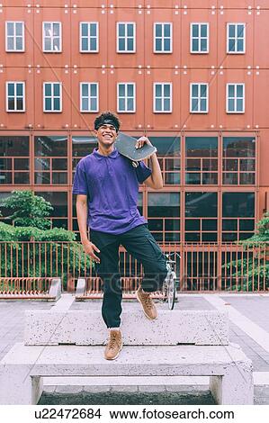 Skateboarder posing with skateboard, Milan, Italy View Large Photo Image Picture - Skateboarder posing with skateboard, Milan, Italy. Fotosearch