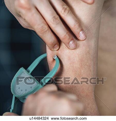Picture - Skinfold test for body fat. Fotosearch