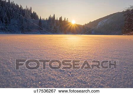 Snow covered lake and forest at sunset View Large Photo Image Stock Photo - Snow covered lake and forest at sunset. Fotosearch