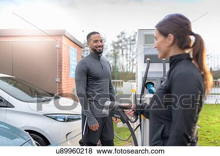 Sportsman and woman charging electric car at charging bay, Manchester, UK View Large Photo Image Stock Photo - Sportsman and woman charging electric car at charging bay, Manchester, UK. Fotosearch