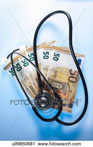 Stock Image - Stethoscope and money depicting medical costs.. Fotosearch