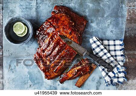 Still life with BBQ spare ribs and kitchen knife, overhead view View Large Photo Image Stock Photo - Still life with BBQ spare ribs and kitchen knife, overhead view. Fotosearch
