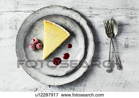 Still life with lemon tart and raspberries on plate, overhead view View Large Photo Image Stock Photo - Still life with lemon tart and raspberries on plate, overhead view. Fotosearch