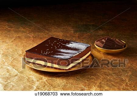 Stock Image - Still life with triple chocolate dessert on gold plate, christmas dessert. Fotosearch