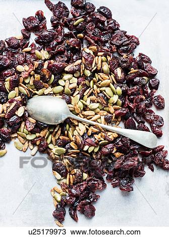 Stock Image - Teaspoon on seeds and dried cranberries. Fotosearch