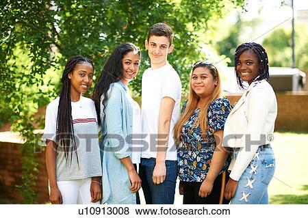 Stock Photo - Teenage boy and higher education students on college campus, portrait. Fotosearch