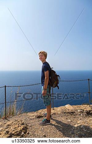 Stock Photography - Teenage boy on coast, full length portrait, Vernazza, Liguria, Italy. Fotosearch
