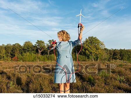 Picture - Teenage girl powering LED light using miniature wind turbine, Netherlands. Fotosearch