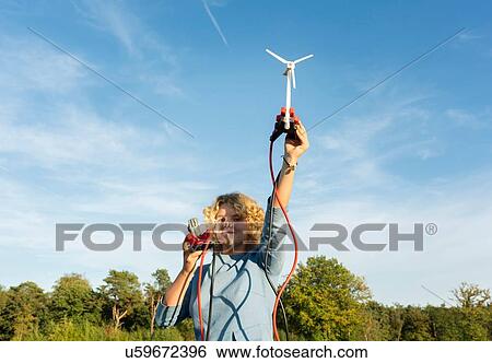Stock Photograph - Teenage girl powering LED light using miniature wind turbine, Netherlands. Fotosearch