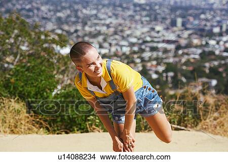 Teenage girl with cropped hair balancing on one leg on cityscape hilltop, Los Angeles, California, USA View Large Photo Image Picture - Teenage girl with cropped hair balancing on one leg on cityscape hilltop, Los Angeles, California, USA. Fotosearch