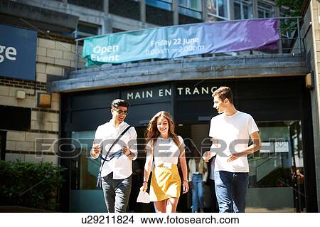 Picture - Teenage girl with young male higher education students leaving college campus. Fotosearch