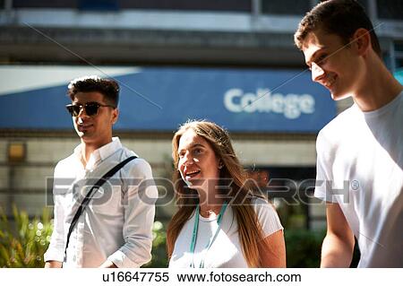 Stock Photography - Teenage girl with young male higher education students leaving college campus. Fotosearch