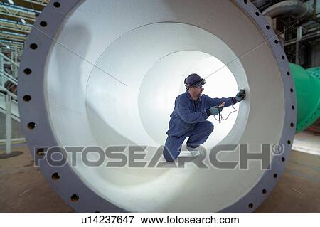 Stock Photo - Testing protective paint in large pipe in turbine hall of nuclear power station. Fotosearch