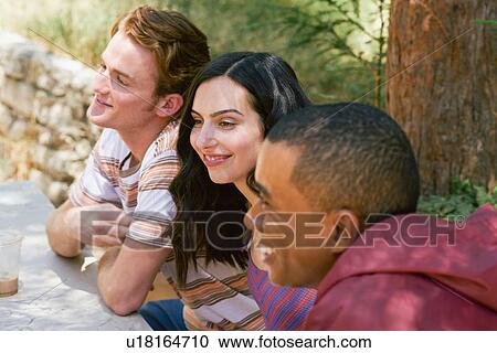 Three young adult friends chatting at park picnic table, Los Angeles, California, USA View Large Photo Image Stock Image - Three young adult friends chatting at park picnic table, Los Angeles, California, USA. Fotosearch