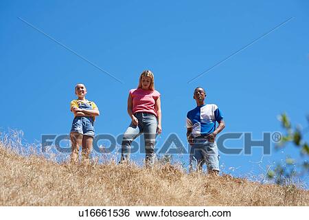 Three young adult friends on top of hill in park, low angle view, Los Angeles, California, USA View Large Photo Image Stock Photograph - Three young adult friends on top of hill in park, low angle view, Los Angeles, California, USA. Fotosearch