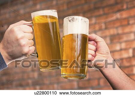 Stock Image - Toasting with beer. Fotosearch