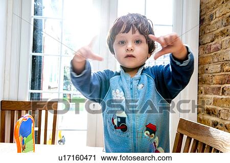 Stock Image - Toddler boy making shapes with his fingers. Fotosearch