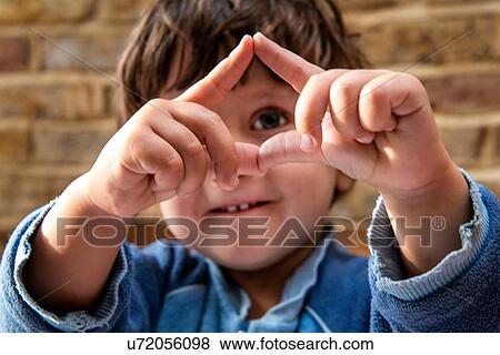 Stock Photo - Toddler boy making shapes with his fingers. Fotosearch