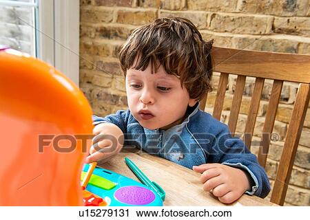 Toddler boy using toy laptop View Large Photo Image Stock Image - Toddler boy using toy laptop. Fotosearch